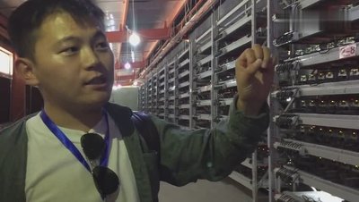 A large warehouse filled with rows of mining rigs.